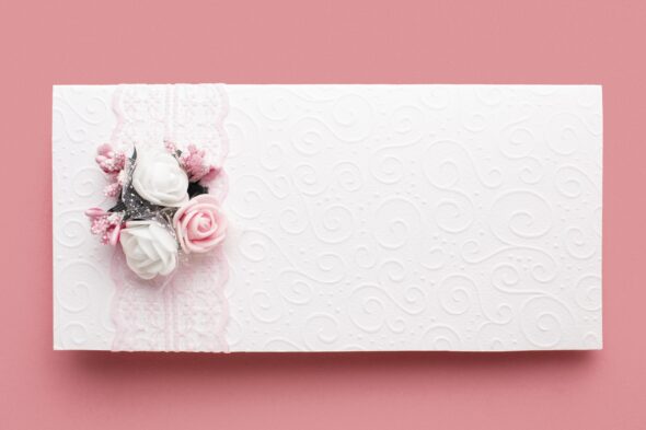 Elegant wedding cards displayed on a table with floral decorations.