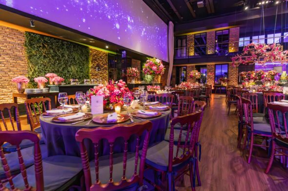 A beautifully decorated Pakistani wedding venue with modern floral arrangements and lighting.